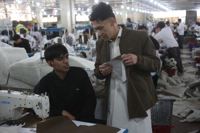 (251207) -- KABUL, Dec. 7, 2025 (Xinhua) -- Zakria Sadeq Moradi (R), founder of Max Garment Factory, talks with a worker at Max Garment Factory in Kabul, Afghanistan, on Dec. 4, 2025. TO GO WITH "Feature: Afghanistan's largest garment factory weaves new pathways with China-sourced materials" (Photo by Saifurahman Safi/Xinhua)