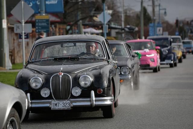 (251208) -- RICHMOND, Dec. 8, 2025 (Xinhua) -- Classic cars cruise down the street during the annual Christmas Classic Car Cruise event in Richmond, British Columbia, Canada, Dec. 7, 2025.
  The annual event was held here on Sunday, featuring dozens of classic vehicles with Christmas decorations parading through the communities and collecting toys for charity. (Photo by Liang Sen/Xinhua)