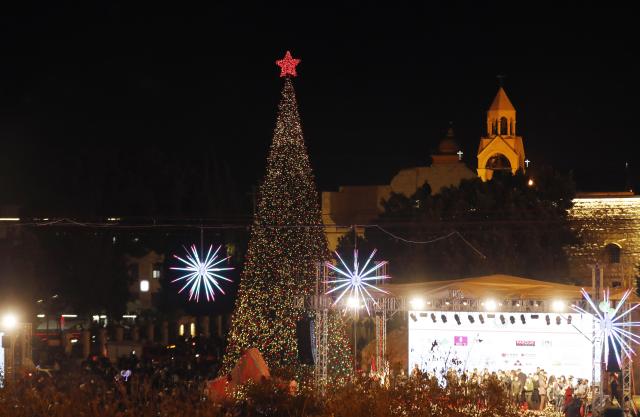 (251208) -- BETHLEHEM, Dec. 8, 2025 (Xinhua) -- A Christmas tree is lit at the Manger Square in Bethlehem, southern West Bank on Dec. 6, 2025. Hundreds of residents and visitors attended a Christmas tree-lighting event here Saturday to mark the beginning of this year's Christmas celebrations. (Photo by Mamoun Wazwaz/Xinhua)