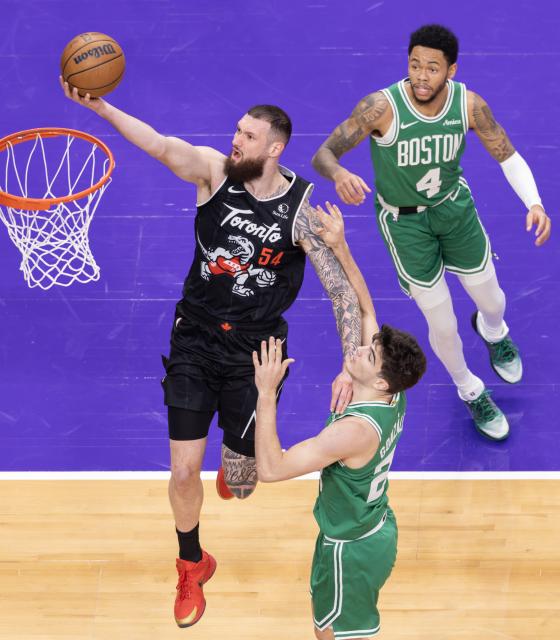 (251208) -- TORONTO, Dec. 8, 2025 (Xinhua) -- Sandro Mamukelashvili (L) of Toronto Raptors goes up for a layup during the 2025-2026 NBA regular season game between Toronto Raptors and Boston Celtics in Toronto, Canada, on Dec. 7, 2025. (Photo by Zou Zheng/Xinhua)