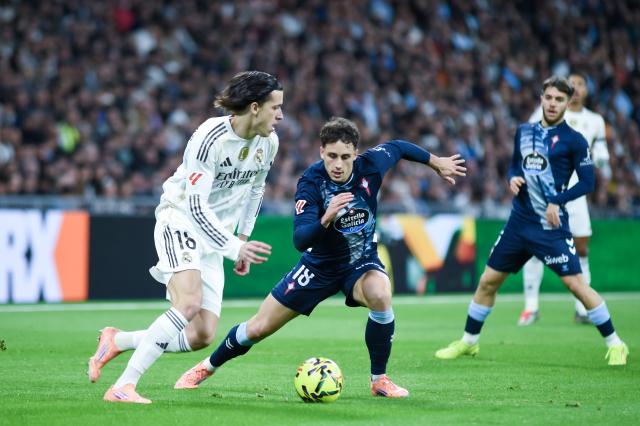 (251208) -- MADRID, Dec. 8, 2025 (Xinhua) -- Real Madrid's Alvaro Carreras (L) vies with Celta Vigo's Pablo Duran during a La Liga football match between Real Madrid and Celta Vigo at Santiago Bernabeu stadium in Madrid, Spain, on Dec. 7, 2025. (Photo by Gustavo Valiente/Xinhua)