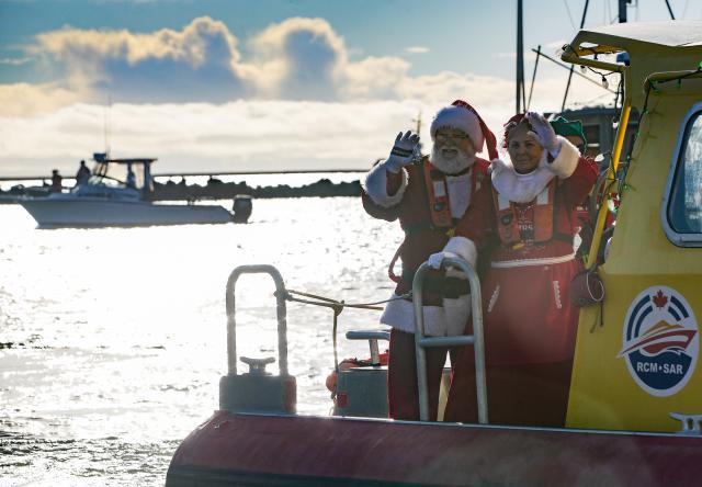 (251208) -- RICHMOND, Dec. 8, 2025 (Xinhua) -- Two persons dressed as Santa Claus and Mrs. Claus wave to the crowd as they travel by boat to Fisherman's Wharf in Steveston Village, Richmond, British Columbia, Canada, Dec. 7, 2025.
  The Santa Claus's arrival event was held here on Sunday, marking the opening of local Christmas celebrations and drawing hundreds of residents to attend. (Photo by Liang Sen/Xinhua)