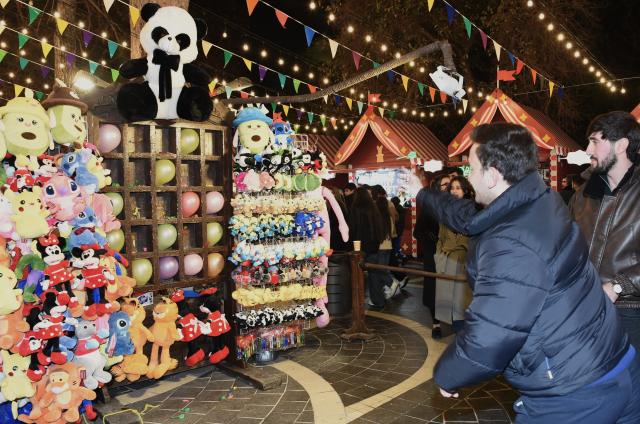 (251208) -- BAKU, Dec. 8, 2025 (Xinhua) -- A man plays a dart game in Baku, Azerbaijan, Dec. 7, 2025.
  Baku is in festive mood as the New Year approaches. (Xinhua/Chen Junfeng)
