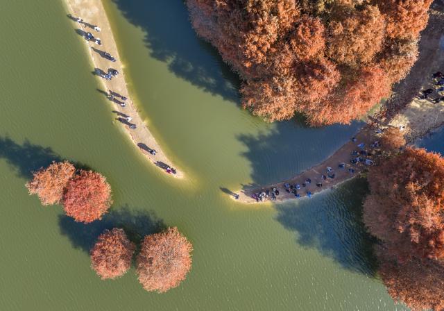 (251208) -- BEIJING, Dec. 8, 2025 (Xinhua) -- An aerial drone photo taken on Dec. 7, 2025 shows tourists visiting a reservoir in Shaoxing City, east China's Zhejiang Province. (Photo by Hu Xuejun/Xinhua)