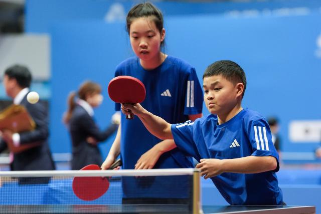 (251208) -- HONG KONG, Dec. 8, 2025 (Xinhua) -- Jiang Longjun (R)/Tong Xinyue of Zhejiang compete during the mixed doubles age 12-15 group A match of special olympics table tennis at China's 12th National Games for Persons with Disabilities and the 9th National Special Olympic Games in Hong Kong, south China, Dec. 8, 2025. (Xinhua/Zhu Zheng)