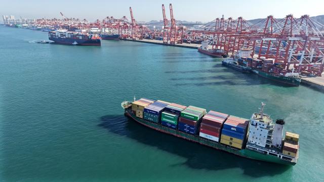 (251208) -- QINGDAO, Dec. 8, 2025 (Xinhua) -- A drone photo taken on Dec. 8, 2025 shows a cargo ship loaded with containers leaving a container terminal of Qingdao Port in Qingdao, east China's Shandong Province. The cargo throughput of Qingdao Port in 2025 surpassed 700 million tonnes on Monday, reaching this milestone 15 days earlier compared to 2024.
   Qingdao Port has continuously expanded its international logistics network, with nearly 240 routes connecting over 700 ports in over 180 countries and regions worldwide. (Xinhua/Li Ziheng)