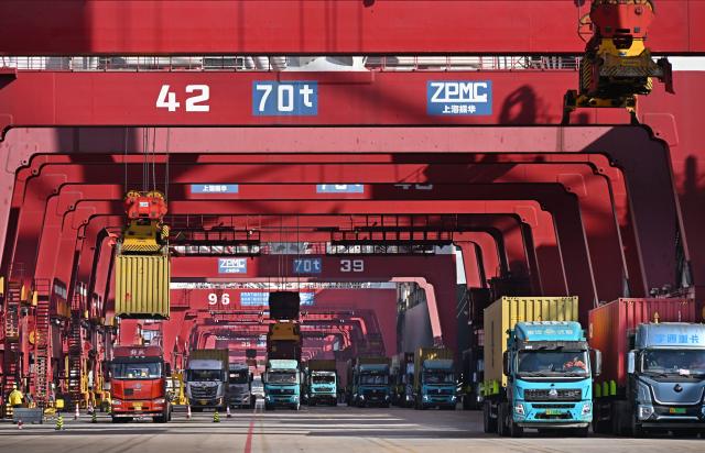 (251208) -- QINGDAO, Dec. 8, 2025 (Xinhua) -- This photo taken on Dec. 8, 2025 shows freight trucks at a container terminal of Qingdao Port in Qingdao, east China's Shandong Province. The cargo throughput of Qingdao Port in 2025 surpassed 700 million tonnes on Monday, reaching this milestone 15 days earlier compared to 2024.
   Qingdao Port has continuously expanded its international logistics network, with nearly 240 routes connecting over 700 ports in over 180 countries and regions worldwide. (Xinhua/Li Ziheng)