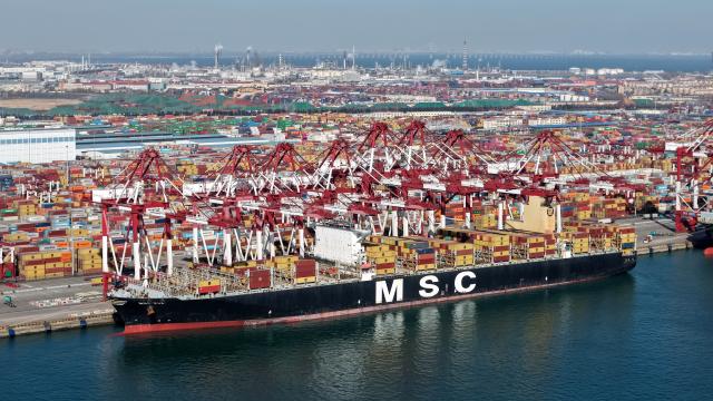 (251208) -- QINGDAO, Dec. 8, 2025 (Xinhua) -- A drone photo taken on Dec. 8, 2025 shows a cargo ship at a container terminal of Qingdao Port in Qingdao, east China's Shandong Province. The cargo throughput of Qingdao Port in 2025 surpassed 700 million tonnes on Monday, reaching this milestone 15 days earlier compared to 2024.
   Qingdao Port has continuously expanded its international logistics network, with nearly 240 routes connecting over 700 ports in over 180 countries and regions worldwide. (Xinhua/Li Ziheng)