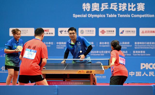 (251208) -- HONG KONG, Dec. 8, 2025 (Xinhua) -- Zhang Liangzhong (top R)/Xia Jinglan (top L) of Jiangsu compete during the mixed doubles age 30+ group A match of special olympics table tennis at China's 12th National Games for Persons with Disabilities and the 9th National Special Olympic Games in Hong Kong, south China, Dec. 8, 2025. (Xinhua/Zhu Zheng)