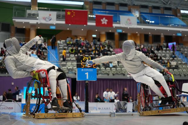 (251209) -- HONG KONG, Dec. 9, 2025 (Xinhua) -- Cheng Yang (L) of Jiangsu and Wang Jianqiang of Shanghai compete during the Men's Sabre Individual category A quarterfinals of Wheelchair Fencing event at China's 12th National Games for Persons with Disabilities and the 9th National Special Olympic Games in Hong Kong, south China, Dec. 9, 2025. (Xinhua/Hou Zhaokang)
