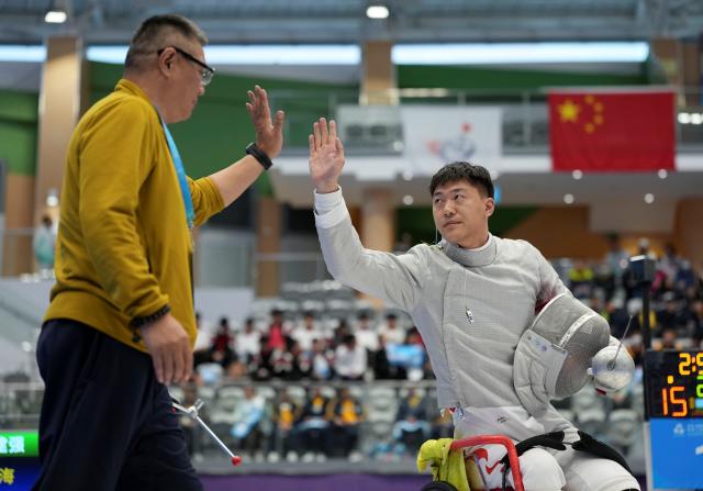 (251209) -- HONG KONG, Dec. 9, 2025 (Xinhua) -- Cheng Yang (R) of Jiangsu celebrates after the Men's Sabre Individual category A quarterfinals of Wheelchair Fencing event at China's 12th National Games for Persons with Disabilities and the 9th National Special Olympic Games in Hong Kong, south China, Dec. 9, 2025. (Xinhua/Hou Zhaokang)