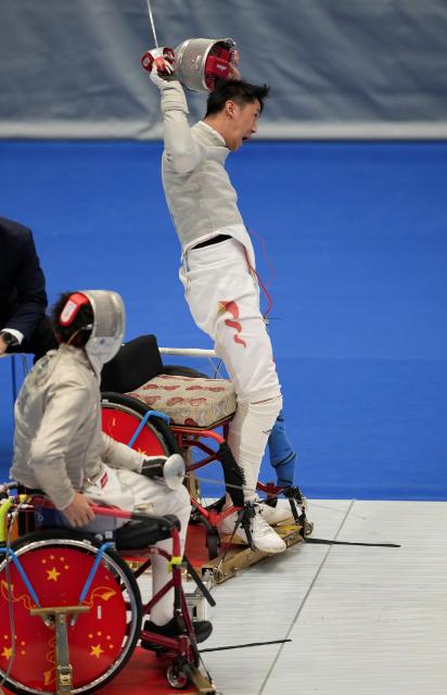 (251209) -- HONG KONG, Dec. 9, 2025 (Xinhua) -- Tian Jianquan (back) of Jiangsu celebrates after the Men's Sabre Individual category A final of Wheelchair Fencing event at China's 12th National Games for Persons with Disabilities and the 9th National Special Olympic Games in Hong Kong, south China, Dec. 9, 2025. (Xinhua/Hou Zhaokang)