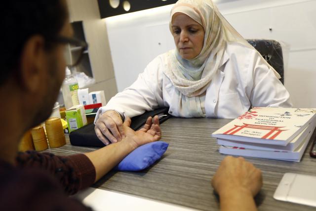 (251209) -- CAIRO, Dec. 9, 2025 (Xinhua) -- Egyptian physiotherapist and acupuncturist Abir El-Naggar feels the pulse of a man at a clinic in Cairo, Egypt, Nov. 30, 2025. TO GO WITH "Feature: Traditional Chinese medicine offers relief, healing to Egyptian patients" (Xinhua/Ahmed Gomaa)