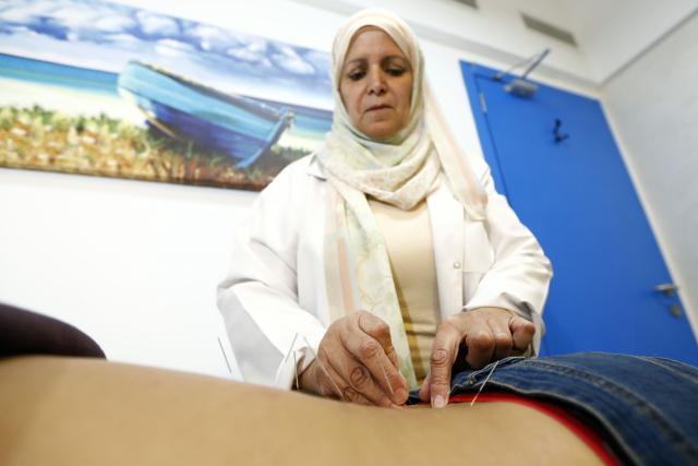 (251209) -- CAIRO, Dec. 9, 2025 (Xinhua) -- Egyptian physiotherapist and acupuncturist Abir El-Naggar performs acupuncture treatment on a man at a clinic in Cairo, Egypt, Nov. 30, 2025. TO GO WITH "Feature: Traditional Chinese medicine offers relief, healing to Egyptian patients" (Xinhua/Ahmed Gomaa)