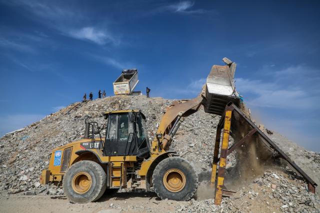 (251209) -- GAZA, Dec. 9, 2025 (Xinhua) -- A bulldozer transports the debris of homes destroyed in earlier Israeli airstrikes to a large dumping site, in the southern Gaza Strip city of Khan Younis, on Dec. 8, 2025. (Photo by Rizek Abdeljawad/Xinhua)