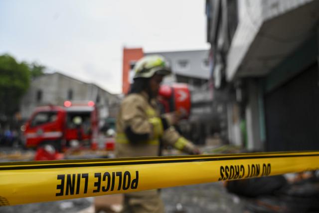 (251210) -- BEIJING, Dec. 10, 2025 (Xinhua) -- A police line is installed at the site of a fire that hits the Terra Drone office building in Jakarta, Indonesia, on Dec. 9, 2025. A total of 22 people were confirmed dead after a fire broke out at the Terra Drone office building in Central Jakarta on Tuesday, local authorities said. (Xinhua/Zulkarnain)