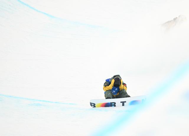 (251210) -- ZHANGJIAKOU, Dec. 10, 2025 (Xinhua) -- Gao Hongbo of China reacts after falling during the men's snowboard halfpipe qualification of FIS Snowboard World Cup 2025 in Zhangjiakou, north China's Hebei Province, Dec. 10, 2025. (Xinhua/Wu Huiwo)
