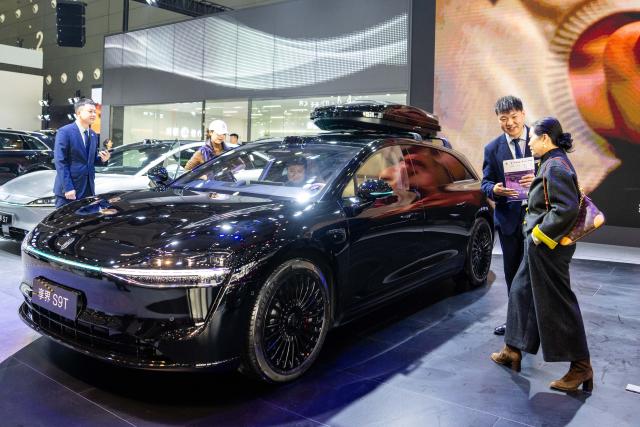 (251210) -- CHANGSHA, Dec. 10, 2025 (Xinhua) -- A visitor (1st R) learns about a car on display at the 21st Changsha International Automobile Expo in Changsha, central China's Hunan Province, on Dec. 10, 2025. The 6-day expo kicked off on Wednesday at the Changsha International Convention and Exhibition Center, showcasing some 1,000 vehicles from over 70 automobile brands. (Xinhua/Chen Sihan)
