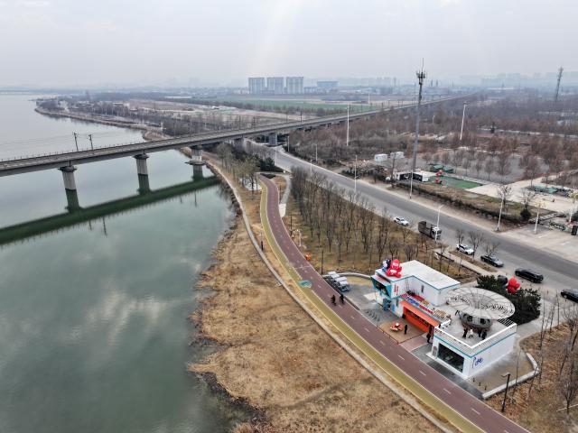 (251210) -- SHIJIAZHUANG, Dec. 10, 2025 (Xinhua) -- An aerial drone photo taken on Dec. 10, 2025 shows an urban ring greenway by the Hutuo River in Shijiazhuang, north China's Hebei Province. The 101-kilometer-long urban ring greenway in Shijiazhuang was made fully accessible to the public on Wednesday. The road facility links multiple waterways as well as 76 parks in the city, providing rich recreational experiences. (Xinhua/Mu Yu)