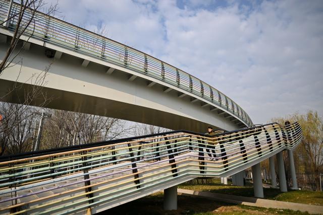 (251210) -- SHIJIAZHUANG, Dec. 10, 2025 (Xinhua) -- Citizens walk on an urban ring greenway which crosses a wetland park in Shijiazhuang, north China's Hebei Province, on Dec. 10, 2025. The 101-kilometer-long urban ring greenway in Shijiazhuang was made fully accessible to the public on Wednesday. The road facility links multiple waterways as well as 76 parks in the city, providing rich recreational experiences. (Xinhua/Mu Yu)
