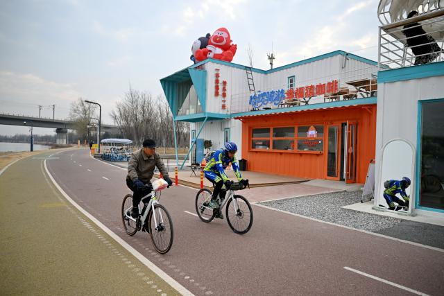(251210) -- SHIJIAZHUANG, Dec. 10, 2025 (Xinhua) -- People ride on an urban ring greenway by the Hutuo River in Shijiazhuang, north China's Hebei Province, on Dec. 10, 2025. The 101-kilometer-long urban ring greenway in Shijiazhuang was made fully accessible to the public on Wednesday. The road facility links multiple waterways as well as 76 parks in the city, providing rich recreational experiences. (Xinhua/Mu Yu)