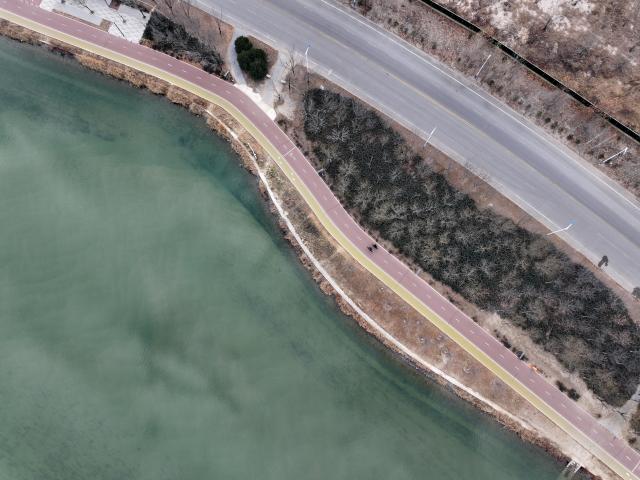 (251210) -- SHIJIAZHUANG, Dec. 10, 2025 (Xinhua) -- An aerial drone photo taken on Dec. 10, 2025 shows people riding on an urban ring greenway by the Hutuo River in Shijiazhuang, north China's Hebei Province. The 101-kilometer-long urban ring greenway in Shijiazhuang was made fully accessible to the public on Wednesday. The road facility links multiple waterways as well as 76 parks in the city, providing rich recreational experiences. (Xinhua/Mu Yu)