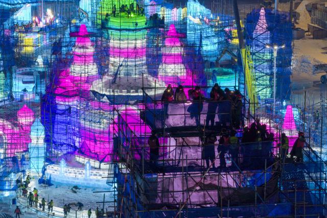 (251210) -- HARBIN, Dec. 10, 2025 (Xinhua) -- A drone photo taken on Dec. 10, 2025 shows workers at the construction site of the main tower of the Harbin Ice and Snow World in Harbin, northeast China's Heilongjiang Province. The main tower of the 27th edition of Harbin Ice and Snow World was topped out on Wednesday, which costs 39,000 cubic meters of ice to build. (Xinhua/Zhang Tao)