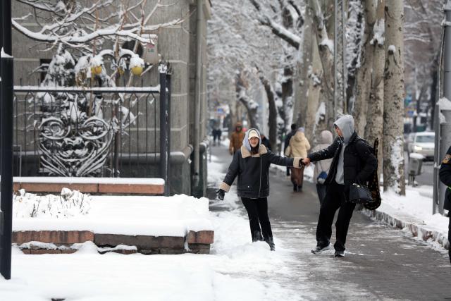 (251210) -- BISHKEK, Dec. 10, 2025 (Xinhua) -- This photo taken on Dec. 10, 2025 shows pedestrians in a street after snow in Bishkek, Kyrgyzstan. (Photo by Roman/Xinhua)