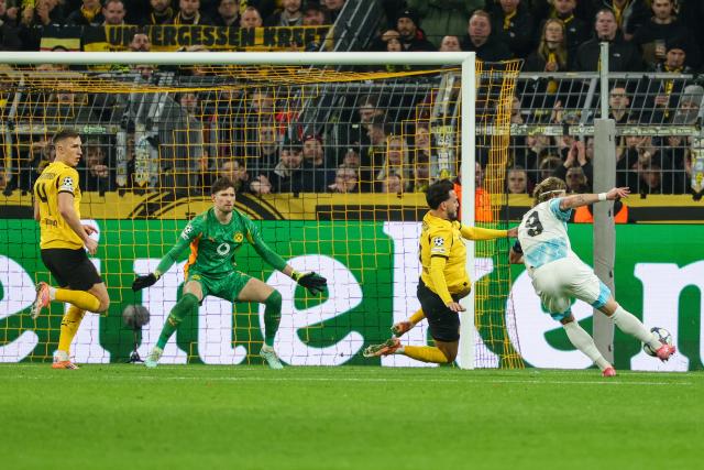(251211) -- DORTMUND, Dec. 11, 2025 (Xinhua) -- Kasper Hogh (1st R) of Bodo/Glimt shoots during the UEFA Champions League football match between Borussia Dortmund and Bodo/Glimt in Dortmund, Germany, Dec. 10, 2025. (Photo by Joachim Bywaletz/Xinhua)