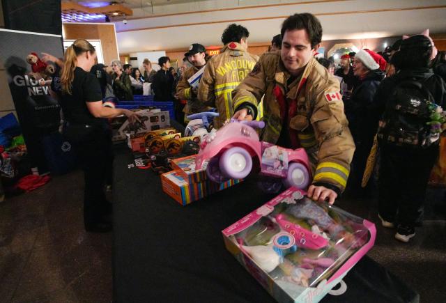 (251211) -- VANCOUVER, Dec. 11, 2025 (Xinhua) -- Firefighters help collect toy donations during the Pan Pacific Christmas Wish Breakfast 2025 at Canada Place in Vancouver, British Columbia, Canada, on Dec. 10, 2025. As one of Canada's largest one-day toy drives, the annual Pan Pacific Christmas Wish Breakfast was held on Wednesday. The event collected more than 20 tonnes of toys, bringing joy to children and providing support to families in need. (Photo by Liang Sen/Xinhua)