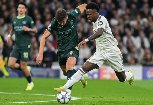 (251211) -- MADRID, Dec. 11, 2025 (Xinhua) -- Vinicius Junior (R) of Real Madrid vies for the ball during the UEFA Champions League football match between Real Madrid and Manchester City in Madrid, Spain, Dec. 10, 2025. (Xinhua/Cheng Min)