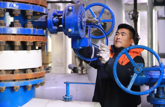 (251211) -- BEIJING, Dec. 11, 2025 (Xinhua) -- A staff member of a heating company checks heating facilities in Wenxian County of Jiaozuo City, central China's Henan Province, Dec. 10, 2025.
  The National Meteorological Center on Wednesday issued a blue alert for a cold wave and a separate blue alert for strong winds, forecasting a widespread drop in temperatures and the first large-scale snowfall this winter across northern China over the next few days. (Photo by Xu Hongxing/Xinhua)