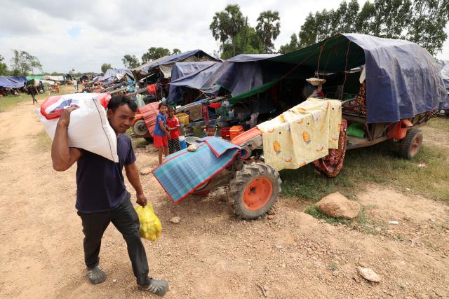 (251211) -- SIEM REAP, Dec. 11, 2025 (Xinhua) -- A Cambodian evacuee carries relief items at a safe zone in Siem Reap province, Cambodia, on Dec. 11, 2025. At least 10 Cambodian civilians have been killed and 60 others wounded in the latest round of border conflict with Thailand, a Cambodian Defense Spokesperson said on Thursday. (Photo by Sovannara/Xinhua)