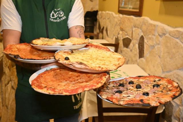 (251211) -- ROME, Dec. 11, 2025 (Xinhua) -- This photo taken on Dec. 11, 2025 shows pizzas at a restaurant named Ivo a Trastevere in Rome, Italy. Italian cuisine has been recognized by the United Nations Educational, Scientific and Cultural Organization (UNESCO) as part of the world's intangible cultural heritage, Italian authorities announced on Wednesday. (Photo by Alberto Lingria/Xinhua)