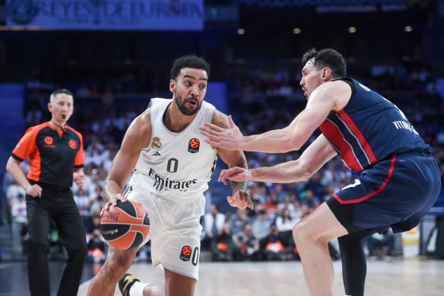 (251212) -- MADRID, Dec. 12, 2025 (Xinhua) -- Real Madrid's Trey Lyles (L) vies with Baskonia's Rodions Kurucs during the Euroleague basketball match between Real Madrid and Baskonia at Movistar Arena in Madrid, Spain, on Dec. 11, 2025. (Photo by Gustavo Valiente/Xinhua)