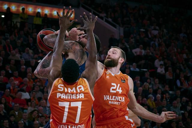 (251212) -- Valencia, Dec. 12, 2025 (Xinhua) -- Matthew Costello (R) and Yankuba Sima (front) of Valencia defend Vincent Poirier of Anadolu Efes Istanbul during the Euroleague basketball match between Valencia and  Anadolu Efes Istanbul in Valencia, Spain, on Dec. 11, 2025. (Str/Xinhua)