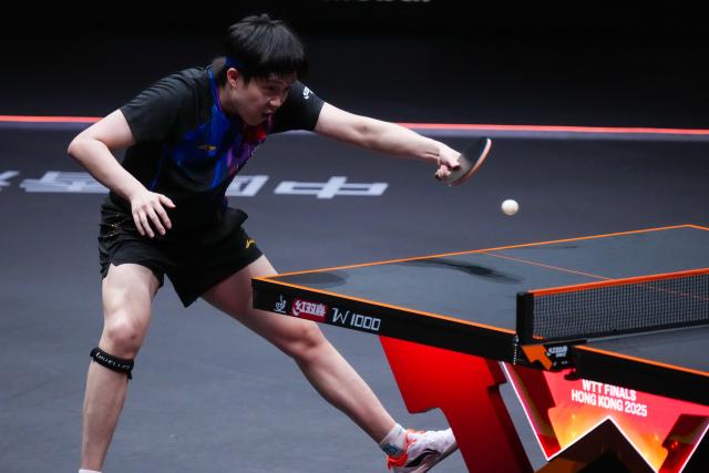 (251212) -- HONG KONG, Dec. 12, 2025 (Xinhua) -- Wang Chuqin of China hits a return during the men's singles quarterfinal match against Alexis Lebrun of France at the WTT Finals Hong Kong 2025 in Hong Kong, south China, Dec. 12, 2025. (Xinhua/Zhu Wei)