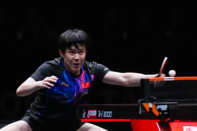 (251212) -- HONG KONG, Dec. 12, 2025 (Xinhua) -- Wang Chuqin of China hits a return during the men's singles quarterfinal match against Alexis Lebrun of France at the WTT Finals Hong Kong 2025 in Hong Kong, south China, Dec. 12, 2025. (Xinhua/Zhu Wei)