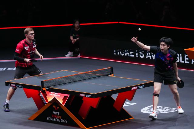 (251212) -- HONG KONG, Dec. 12, 2025 (Xinhua) -- Wang Chuqin (R) of China serves during the men's singles quarterfinal match against Alexis Lebrun of France at the WTT Finals Hong Kong 2025 in Hong Kong, south China, Dec. 12, 2025. (Xinhua/Zhu Wei)