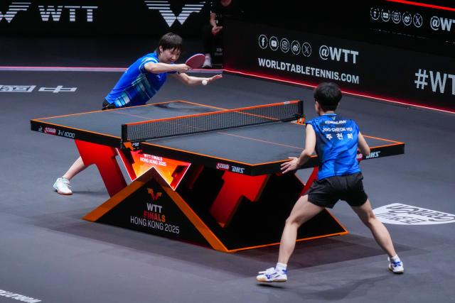 (251212) -- HONG KONG, Dec. 12, 2025 (Xinhua) -- Wang Manyu (L) of China hits a return during the women's singles quarterfinal match against Joo Cheonhui of South Korea at the WTT Finals Hong Kong 2025 in Hong Kong, south China, Dec. 12, 2025. (Xinhua/Zhu Wei)