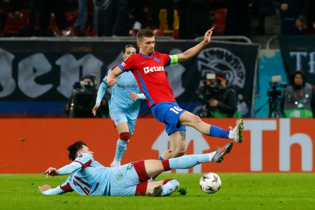 (251212) -- BUCHAREST, Dec. 12, 2025 (Xinhua) -- FCSB's Florin Tanase (R) vies with Feyenoord's Anel Ahmedhodzic (bottom) during the UEFA Europa League football match between FCSB and Feyenoord in Bucharest, Romania, Dec. 11, 2025. (Photo by Cristian Cristel/Xinhua)