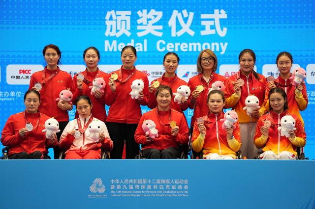 (251212) -- HONG KONG, Dec. 12, 2025 (Xinhua) -- Gold medalists Team Shanghai (C), silver medalists Shanghai-Guangdong United Team (L) and bronze medalists Team Jiangsu pose during the awarding ceremony of the women's epee team final of wheelchair fencing at China's 12th National Games for Persons with Disabilities and the 9th National Special Olympic Games in Hong Kong, south China, Dec. 12, 2025. (Xinhua/Hou Zhaokang)