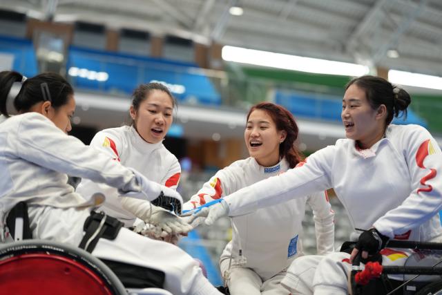 (251212) -- HONG KONG, Dec. 12, 2025 (Xinhua) -- Members of Shanghai-Guangdong United Team cheers prior to the women's epee team final of wheelchair fencing at China's 12th National Games for Persons with Disabilities and the 9th National Special Olympic Games in Hong Kong, south China, Dec. 12, 2025. (Xinhua/Hou Zhaokang)