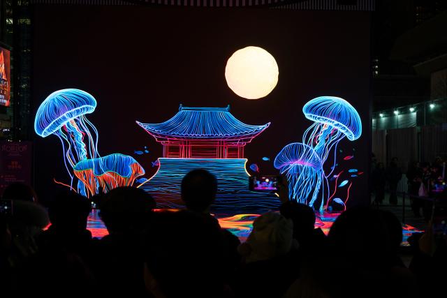 (251212) -- SEOUL, Dec. 12, 2025 (Xinhua) -- People view light installations of the 2025 Seoul Winter Festa at the Gwanghwamun Square in Seoul, South Korea, Dec. 12, 2025. (Photo by Jun Hyosang/Xinhua)