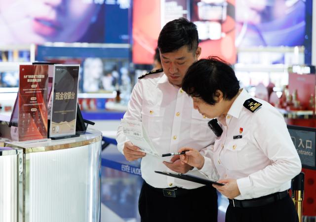 (251212) -- HAIKOU, Dec. 12, 2025 (Xinhua) -- Staff members of Haikou Customs work at a duty-free shopping mall in Haikou, south China's Hainan Province, Dec. 10, 2025. The Hainan Free Trade Port is preparing for island-wide special customs operations starting Dec. 18., a major milestone in the opening-up drive of the world's second-largest economy despite rising protectionism worldwide. (Xinhua/Jin Liwang)