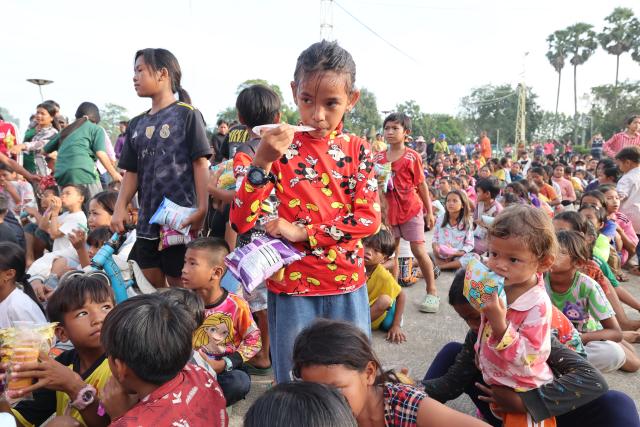 (251212) -- PHNOM PENH, Dec. 12, 2025 (Xinhua) -- Cambodian children gather for snacks donated by charitable persons at a safe zone in Banteay Meanchey province, Cambodia on Dec. 12, 2025. The number of Cambodian evacuees from the ongoing border fighting with Thailand has risen to more than 300,000 as of Friday afternoon, the Cambodian Ministry of Interior said in a press release. (Photo by Sovannara/Xinhua)