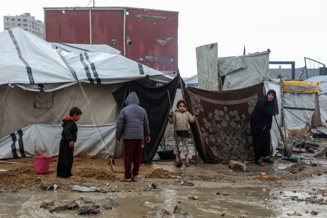 (251212) -- GAZA, Dec. 12, 2025 (Xinhua) -- Palestinians come outside their temporary shelters after rain in Gaza City, on Dec. 12, 2025. At least 14 people were killed in the Gaza Strip over the past 24 hours as homes collapsed and tents sheltering displaced families were flooded during a powerful winter storm, Gaza's Civil Defense said on Friday. (Photo by Rizek Abdeljawad/Xinhua)