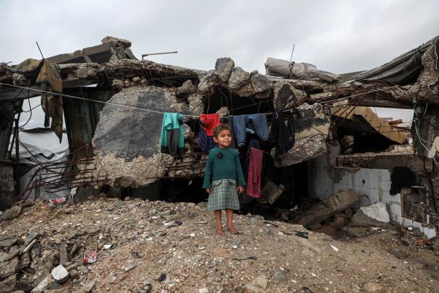 (251212) -- GAZA, Dec. 12, 2025 (Xinhua) -- A Palestinian child stands outside after rain in Gaza City, on Dec. 12, 2025. At least 14 people were killed in the Gaza Strip over the past 24 hours as homes collapsed and tents sheltering displaced families were flooded during a powerful winter storm, Gaza's Civil Defense said on Friday. (Photo by Rizek Abdeljawad/Xinhua)