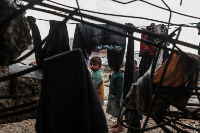 (251212) -- GAZA, Dec. 12, 2025 (Xinhua) -- Palestinian children come outside their temporary shelters after rain in Gaza City, on Dec. 12, 2025. At least 14 people were killed in the Gaza Strip over the past 24 hours as homes collapsed and tents sheltering displaced families were flooded during a powerful winter storm, Gaza's Civil Defense said on Friday. (Photo by Rizek Abdeljawad/Xinhua)