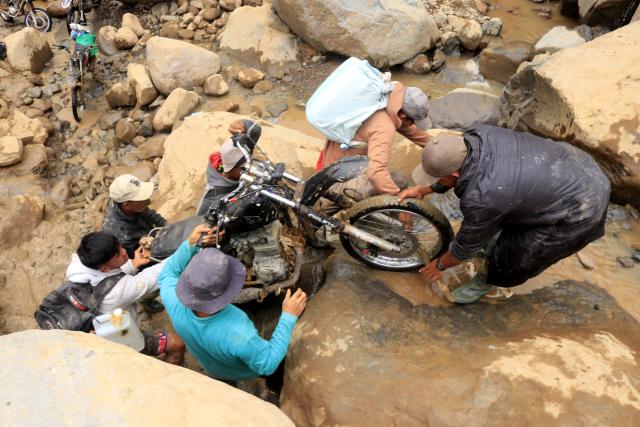 (251213) -- JAKARTA, Dec. 13, 2025 (Xinhua) -- Villagers move a motorcycle across a river after floods and landslides hit Bener Meriah regency in Aceh, Indonesia, Dec. 9, 2025. The death toll from floods and landslides that struck three provinces on Indonesia's Sumatra Island has exceeded 1,000, with 218 people still missing, according to the latest data released Saturday by the National Disaster Management Agency (BNPB). (Photo by Yulham/Xinhua)